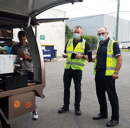 Photo of team in the carpark ordering coffee from our daily coffee van visit